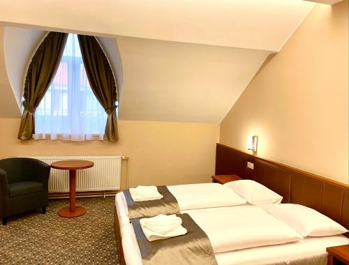 考波什堡Borostyán Panzió的酒店客房,配有两张床和椅子