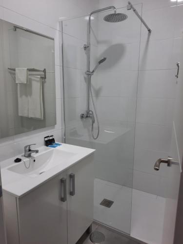 莱佩Hotel Portugal的白色的浴室设有水槽和淋浴。