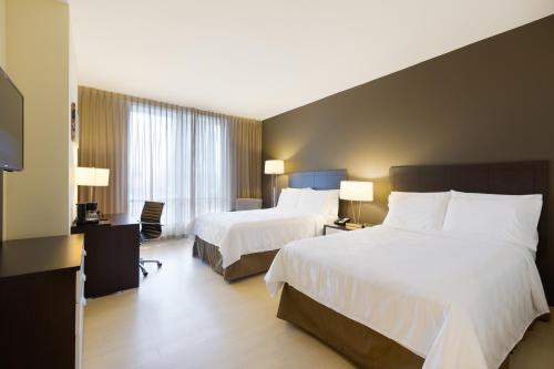 巴拿马城Holiday Inn Panama Distrito Financiero, an IHG Hotel的酒店客房设有两张床和电视。