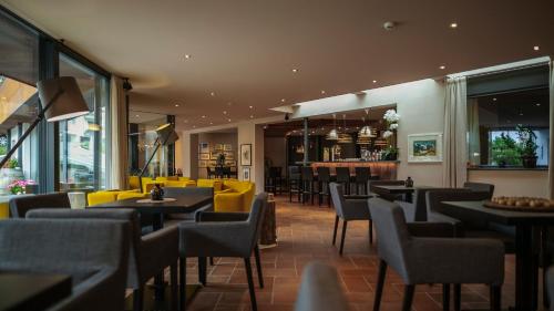 圣瓦伦蒂诺阿拉穆塔施托克尔酒店的一间带桌椅的餐厅和一间酒吧