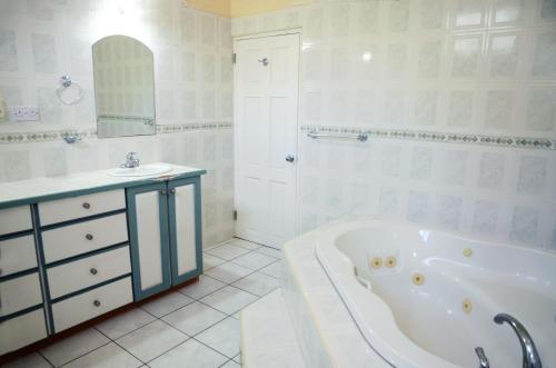 金斯敦Bascombe Apartments的白色的浴室设有浴缸和水槽。