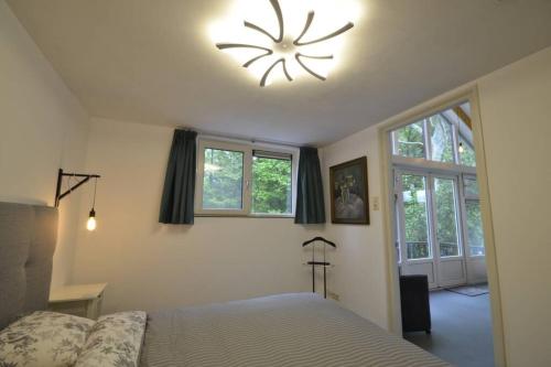 EelderwoldeDINOS - Whole guesthouse - Nearby Groningen and lake的一间卧室设有一张床,天花板上设有时钟