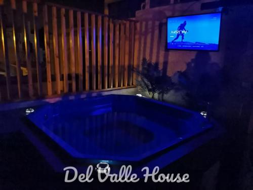 伊察Del Valle House的一间配有电视的客房内的大蓝色浴缸