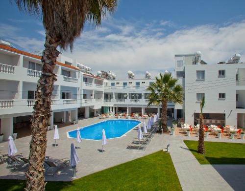 帕福斯普林斯萨维拉公寓式酒店的享有酒店游泳池和棕榈树的景色