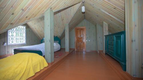 Ch'aisubaniЭко-дом в горах的阁楼卧室设有1张床和木制天花板