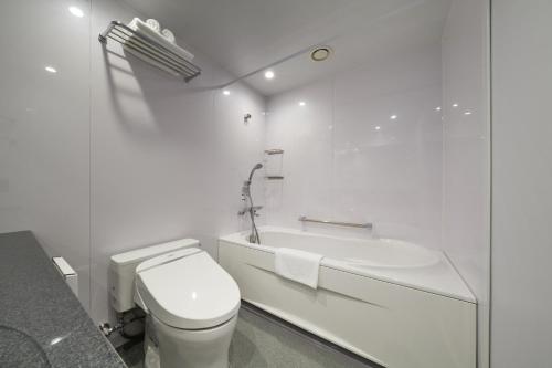 东京MUSTARD HOTEL SHIMOKITAZAWA的白色的浴室设有卫生间和浴缸。
