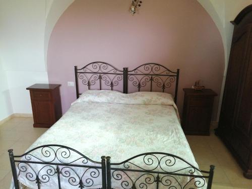 莱韦拉诺Agriturismo Tenuta Perruzzi的一间卧室配有一张带金属床架的床