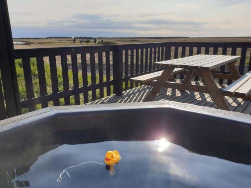 Sandgerði桑德格迪小屋酒店的甲板上的橡皮鸭子,带野餐桌