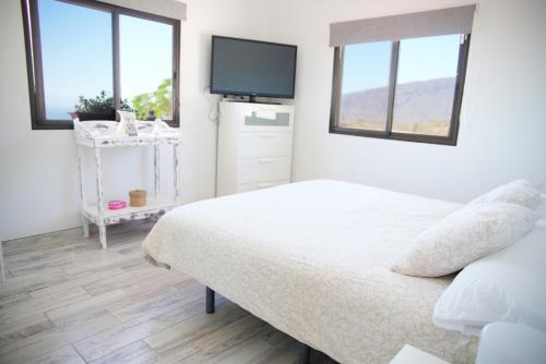 ArafoVilla Carmen Julia 1的卧室配有一张床,墙上配有电视。
