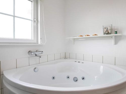 布罗6 person holiday home in Brenderup Fyn的白色浴室设有白色浴缸,配有窗户