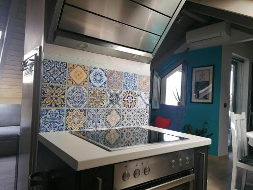 阿尔戈斯托利翁Argostoli loft的厨房的墙壁上铺有蓝色和白色的瓷砖。