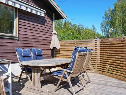 Björkö6 person holiday home in GR DD的甲板上的一张木桌和两把椅子