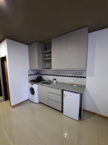 波萨达斯Monoambiente céntrico的厨房配有白色橱柜、洗衣机和烘干机
