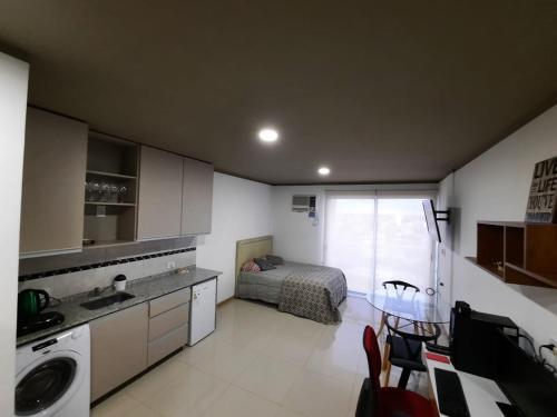 波萨达斯Monoambiente céntrico的一间卧室配有一张床,厨房配有水槽