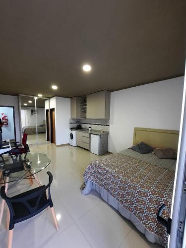 波萨达斯Monoambiente céntrico的一间卧室配有一张床和一张玻璃桌