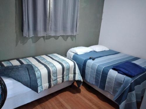 戈亚斯州上帕莱索KITNET'S DA DENI的两张睡床彼此相邻,位于一个房间里