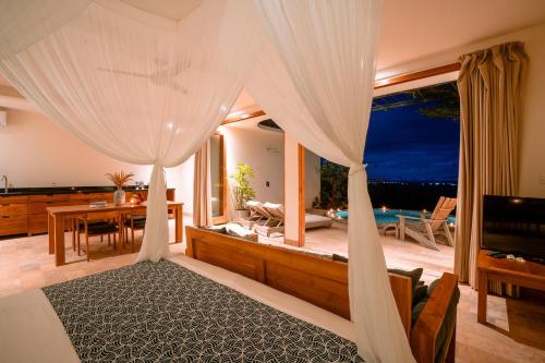 佩母德兰Sumberkima Resort的一间卧室设有一张天蓬床,享有海景