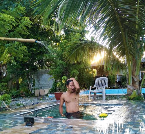 NabasVilla Catalina Bora 3 Resort的站在游泳池里的无衬衫男子