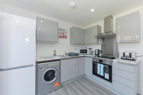 诺丁汉Adbolton House Apartments - Sleek, Stylish, Brand New & Low Carbon的厨房配有洗衣机和洗衣机。