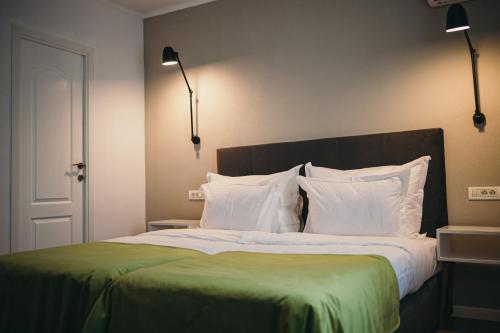 德罗贝塔-塞维林堡Nest Guesthouse的一张带绿毯和白色枕头的床