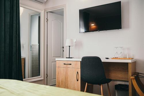 德罗贝塔-塞维林堡Nest Guesthouse的一间设有一张桌子和一台墙上的电视的房间
