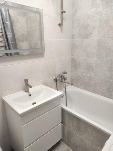 罗夫诺2 комнатная с новым ремонтом, кондиционером, в самом центре的白色的浴室设有水槽和浴缸。