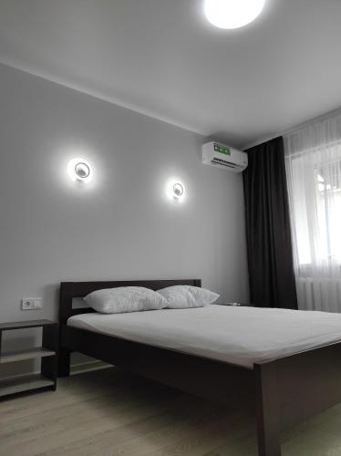 罗夫诺2 комнатная с новым ремонтом, кондиционером, в самом центре的一间卧室配有一张带两个灯的床