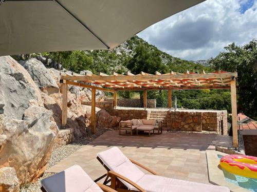 斯塔利格拉德-帕克利尼卡Lovely Holiday Home in Starigrad的一个带遮阳伞和椅子的庭院和一个游泳池