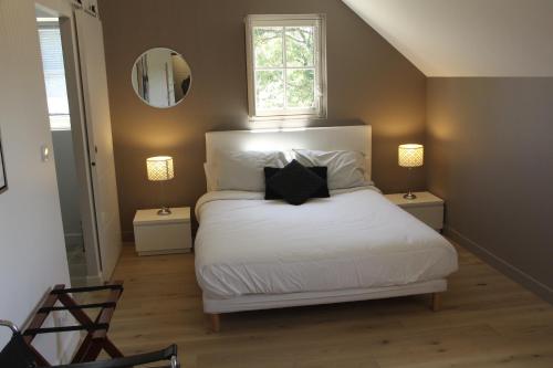 BehuardL'Audacieuse的一间卧室配有一张带白色床单的床和一扇窗户。