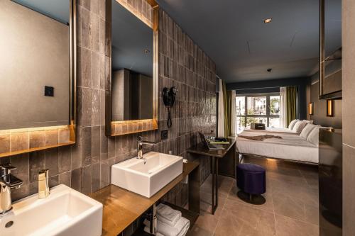 米兰HD8 Hotel Milano的浴室设有2个水槽,床位于后面。
