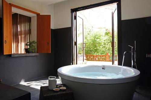 XinpuThe One南园人文客栈的带窗户的浴室设有大浴缸