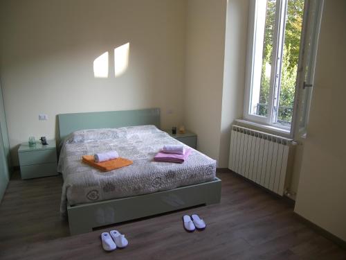 科莫Casa Molinari的卧室配有一张床,地板上配有2个拖鞋