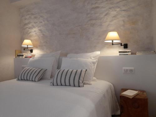 奥佩德Les Guillaume Rey的卧室配有一张白色床、两个枕头和两个灯。