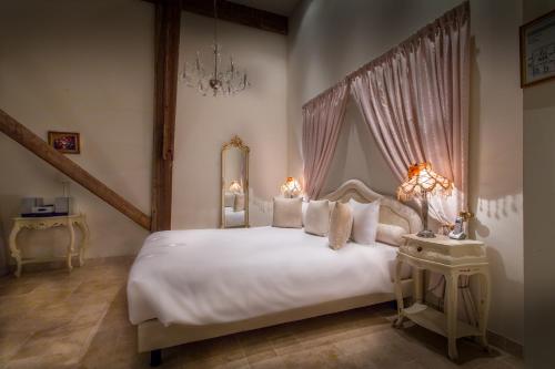 韦斯特莱瓦斯特勒庄园度假酒店的卧室配有一张带吊灯的大型白色床。