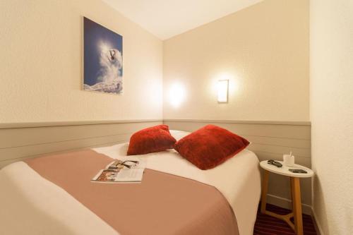La DailleRésidence La Daille - Val-d’Isère的配有两张红色枕头的床的客房