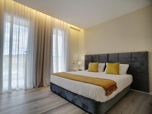 蓬塔德尔加达CFS Azores Guest House的一间卧室配有一张带黄色枕头的大床