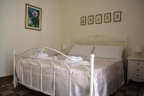 奥斯图尼Casa Il Campanile的卧室配有白色的床、梳妆台和图片