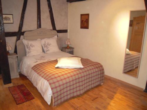 利克维Appartement Le Chez Soi Riquewihr的一间卧室配有带条纹毯子的床