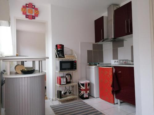 弗兰奎维尔-圣皮尔Charmante Maisonnette indépendante avec parking 5 mn Rouen的厨房配有红色冰箱和微波炉