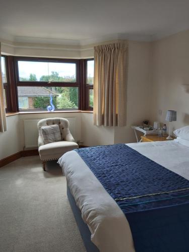 纽马基特拜耶尔雷别墅酒店的卧室配有床、椅子和窗户。