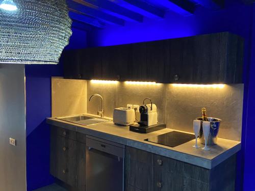 里尔Private Room & Spa avec jacuzzi privatif的厨房配有水槽和蓝色灯光