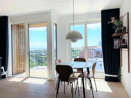 哥本哈根ApartmentInCopenhagen Apartment 1453的一间带桌椅和窗户的用餐室