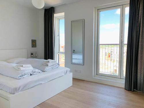 哥本哈根ApartmentInCopenhagen Apartment 1453的卧室设有白色的床和大窗户