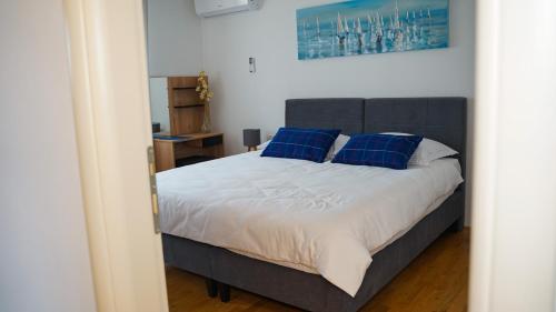 VerunićApartment Aria的一间卧室配有一张带蓝色枕头的大床