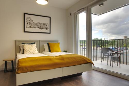 波兹南Essence Apartments Topaz的一间卧室设有一张床和一个阳台
