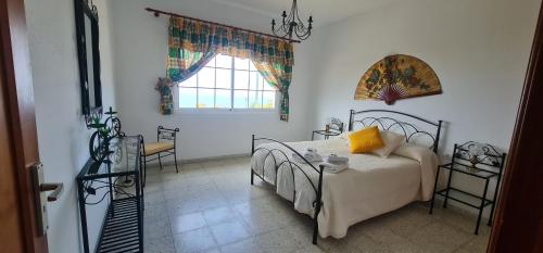 蒂哈拉费Casa Lulu的一间卧室设有一张床、一个窗口和一张桌子