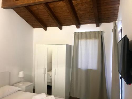 Aci SantʼAntonioAgricampeggio Verde Etna的一间卧室配有床、镜子和窗帘