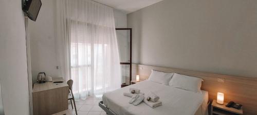 索托马里纳Hotel Ammare的卧室配有白色床和毛巾