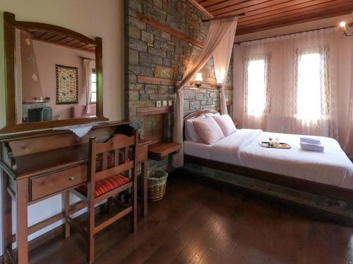 桑加拉达阿玛俄雅传统旅馆的一间卧室配有一张床、一张书桌和一面镜子