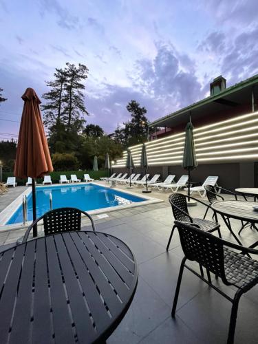科布列季Hotel Condori的一个带椅子和桌子的游泳池以及一把遮阳伞